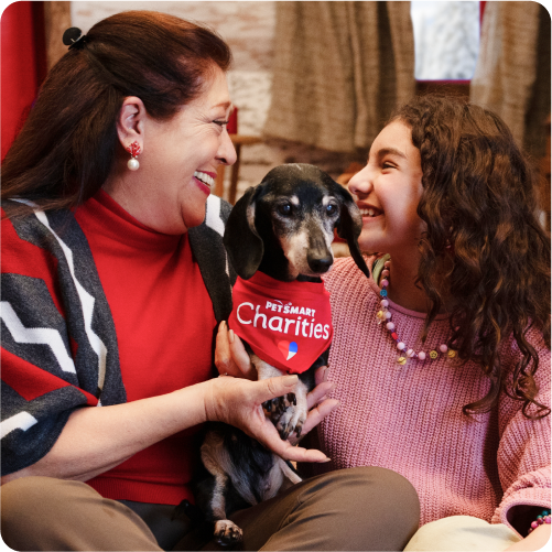 two women holding a dog